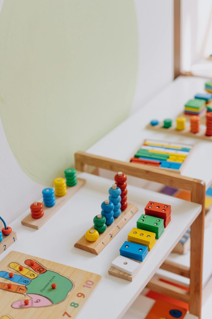 Angebote für Familien Bright and colorful educational wooden toys displayed on a table in a classroom.